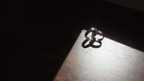 Wedding rings stand on a table that illuminate bright sunlight with interesting Stock Footage 306146100
