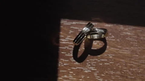 Wedding rings stand on a table that shine bright sunlight with interesting Video stock 306146092