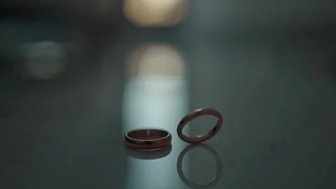 Wedding rings on the table. One ring rotates for a long time Stock Footage 220448694