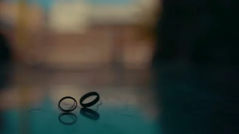 Wedding rings on the table. One ring rotates for a long time Video stock 220955715