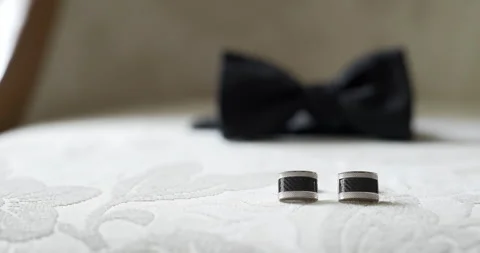 Wedding rings on white bedding with blurred bow tie Vídeo Stock 336472456