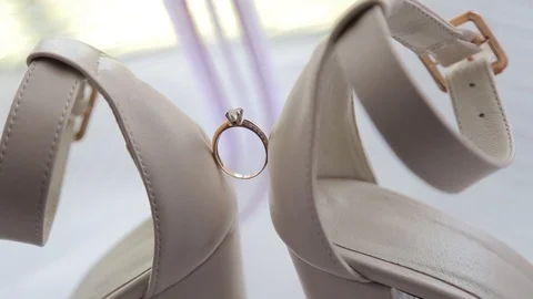 Wedding rings on women's white shoes. Beautiful wedding ring on the bride's Vidéo 123779523