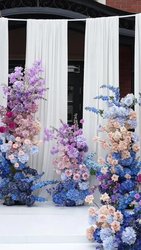 Wedding romantic flower arch on a white podium outdoors with fabric in blue pink Video stock 319045804