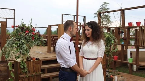 Wedding in rustic style. Lovers standing at the altar, holding hands. Stock Footage 69888823