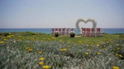 Wedding setup by the ocean with chairs arranged for guests in a sunny location 库存影片 341346182