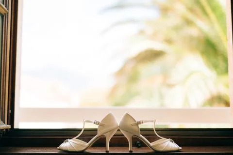 Wedding shoes of the bride at a window Fotos Stock
