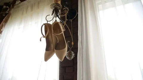 Wedding shoes hang on the sconces Stock Footage 83398687