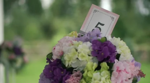 Wedding stands with numbered tables yellow, white, pink and lavender flowers Stock Footage 68790544
