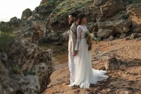 Wedding on the sunset with live floristry. Bride and groom in boho style. Stock Photos