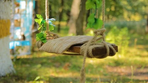Wedding swing decorated with rope hanging on the branches of the old willow Stock Footage 82983048