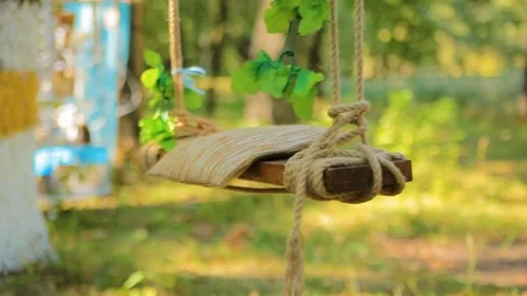 Wedding swing decorated with rope hanging on the branches of the old willow Stock Footage 82983199