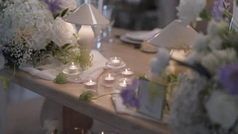 Wedding Table with Candles Table Lamps and White Flower Centerpieces Stock Footage 343707866