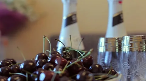 The wedding table. Champagne, cherries and white flowers. Stock Footage 68657135
