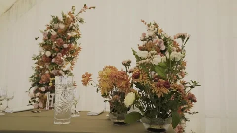 A wedding table decorated with flowers at which the newlyweds are sitting Stock Footage 328314606