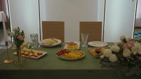 A wedding table decorated with flowers at which the newlyweds are sitting Stock-Footage 329092302