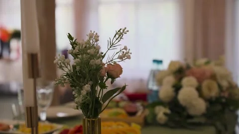 A wedding table decorated with flowers at which the newlyweds are sitting Stock Footage 329092316