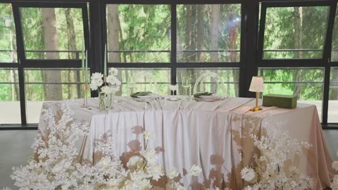 A wedding table decorated with flowers at which the newlyweds are sitting Video stock 329092749