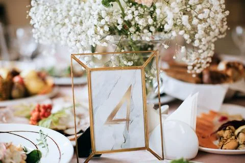 Wedding table decoration in a restaurant. Table number Stock Photos