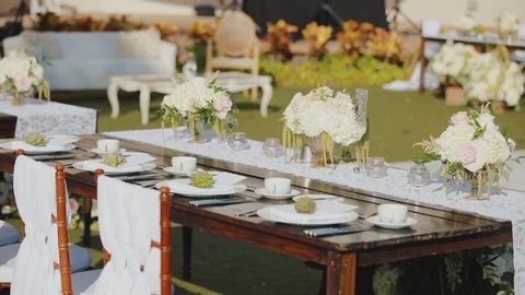 Wedding table decoration with utensils and bouquets of flowers outdoors of Stock Footage 101119320
