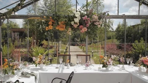 Wedding table in a greenhouse. Wedding decor, festive dinner or party, with Stock Footage 307221013
