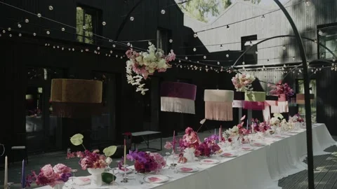 Wedding table served outside and decorated with chandeliers, candles, and Stock Footage 232486369