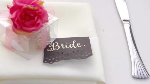 Wedding table setting. Card reads bride. Silver butter knife. Pink flower Stock Footage 136262840