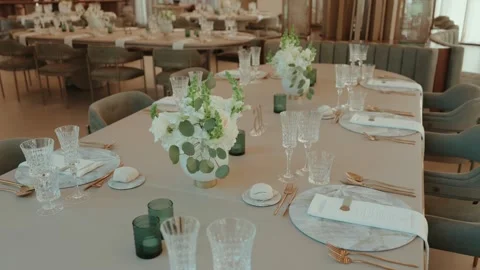 Wedding Table Setting with Crystal Glasses Gold Cutlery and White Flower Stock Footage 343697488