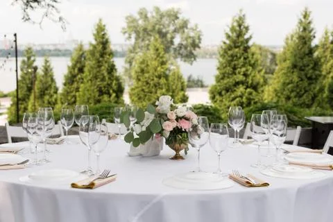 Wedding table setting decorated with fresh flowers in a brass vase. Wedding f Stock Photos