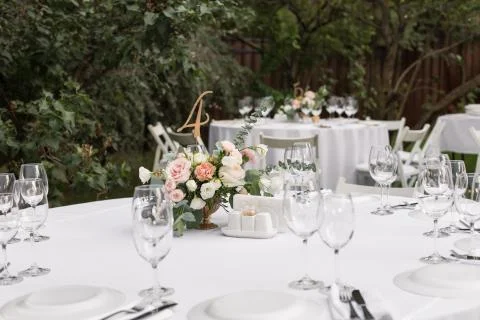 Wedding table setting decorated with fresh flowers in a brass vase. Wedding f Stock Photos