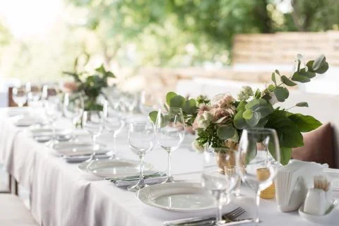 Wedding table setting decorated with fresh flowers in a brass vase. Wedding f Stock Photos