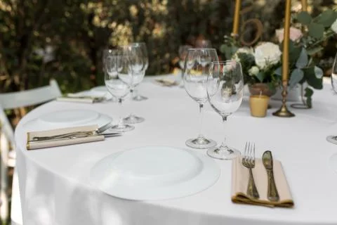 Wedding table setting decorated with fresh flowers in a brass vase. Wedding f Stock Photos