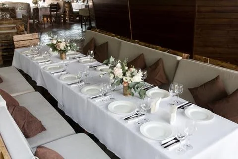 Wedding table setting decorated with fresh flowers in a brass vase. Wedding f Stock Photos