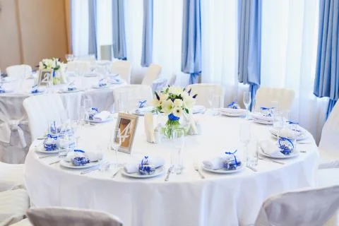 Wedding table setting in the restaurant on the white and blue background. Stock Photos