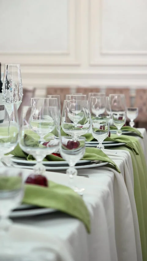Wedding table setting. in white, green and red tones. green cloth napkins, glass Stock Footage 318922287