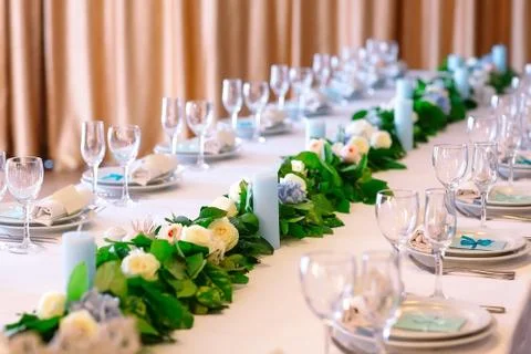 Wedding table settings. Empty plates and glasses on a white tablecloth. Stock Photos