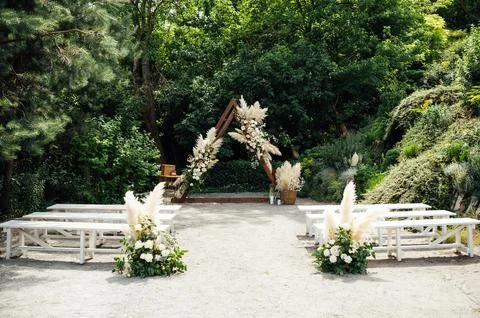 Wedding triangular arch with roses on the background of nature Stock Photos