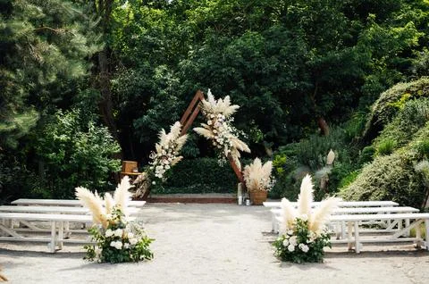 Wedding triangular arch with roses on the background of nature Stock Photos