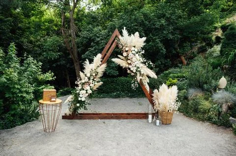 Wedding triangular arch with roses on the background of nature Stock Photos