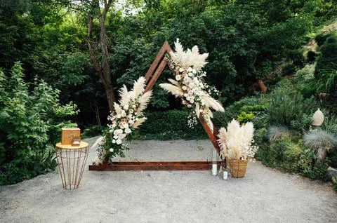Wedding triangular arch with roses on the background of nature Stock Photos