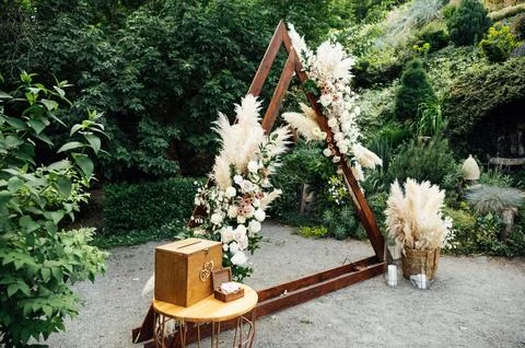 Wedding triangular arch with roses on the background of nature Stock Photos