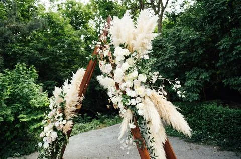 Wedding triangular arch with roses on the background of nature Stock Photos