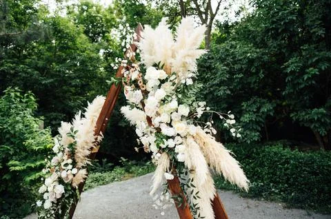 Wedding triangular arch with roses on the background of nature Stock Photos