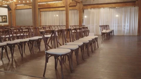 Wedding venue brown chairs with white seat cushions and string lights Stock Footage 242540163