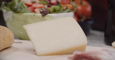 Wedge of hard cheese surrounded by fresh vegetables Stock-Footage 100976260