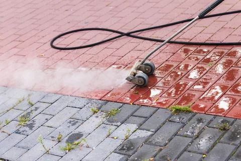 Weed control on the footpath with steam Stock Photos