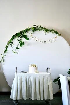 Weeding cake with letters V and M on the serving table against the backgrou.. Stock Photos