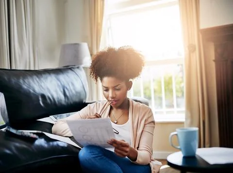 The weekends are perfect for home admin maintenance. a young woman going through Stock Photos