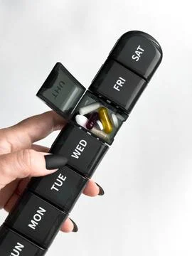 Weekly pill organizer with assorted medication Daily health management Stock Photos