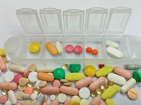 Weekly Pill Organizer with Assorted Tablets and Vitamins Healthcare and Medicat Stock Photos