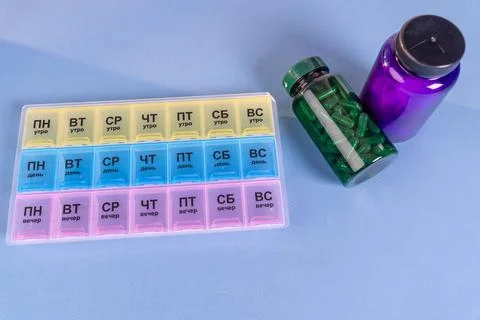 Weekly pill organizer with different compartments placed on a blue backgrou.. Fotos de archivo